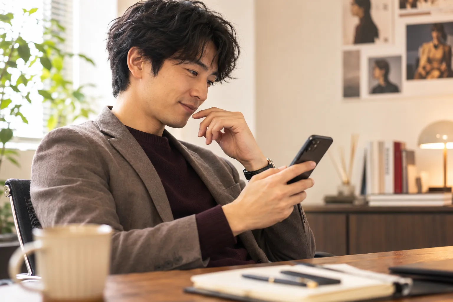 スマートフォンで新着の案件に気づくマネージャー